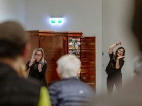Gesture tour facilitators at CAC with their hands up in front of an art installation.
