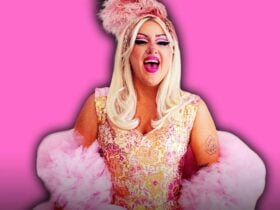 A woman in a corset dress and a tulle boa, laughing with feathers in her hair