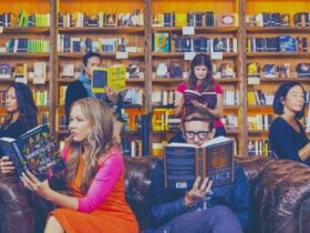 People sitting around reading in front of a large bookcase