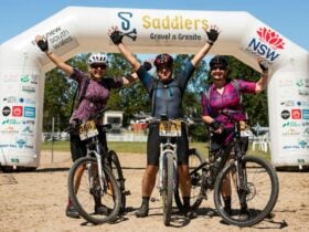 Three riders celebrating their ride as they come across the finish line.