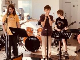 Three children performing in a band