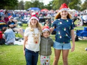 Children with Santa hats on celebrating Carols