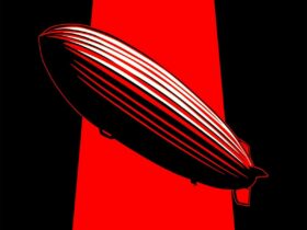 A large red and black Zeppelin balloon floats in front of a red and black background