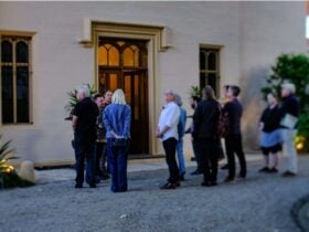 group of people standing out the front of an old building