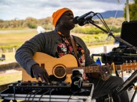 Singer playing guitar with mount canobolas in the background