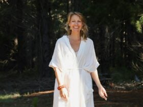 Madeline in a qhite dress smiling at the camera
