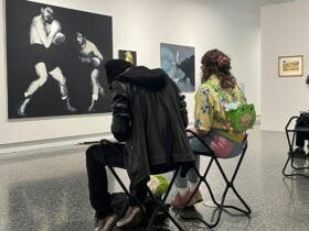 Two young people sitting and sketching in an art exhibition