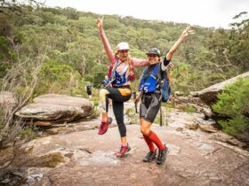 Two teammates pose mid-race together in the Royal National Park Bushland