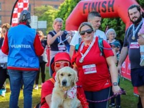 two people in red with their dog
