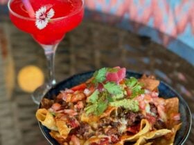 big plate of nachos and red cocktail