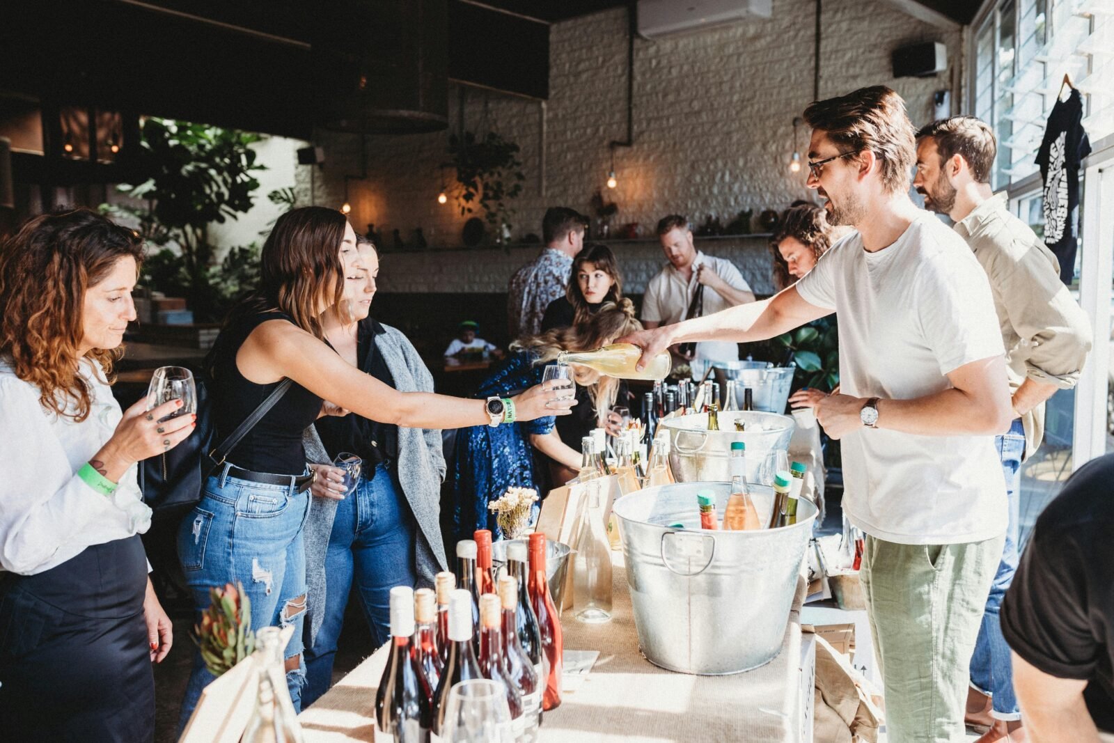 people enjoying tasting of wines from wine producer. Table with a range of beverages available