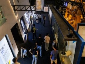 Visitors explore the Navy 125 exhibition, featuring historic portraits and maritime displays.