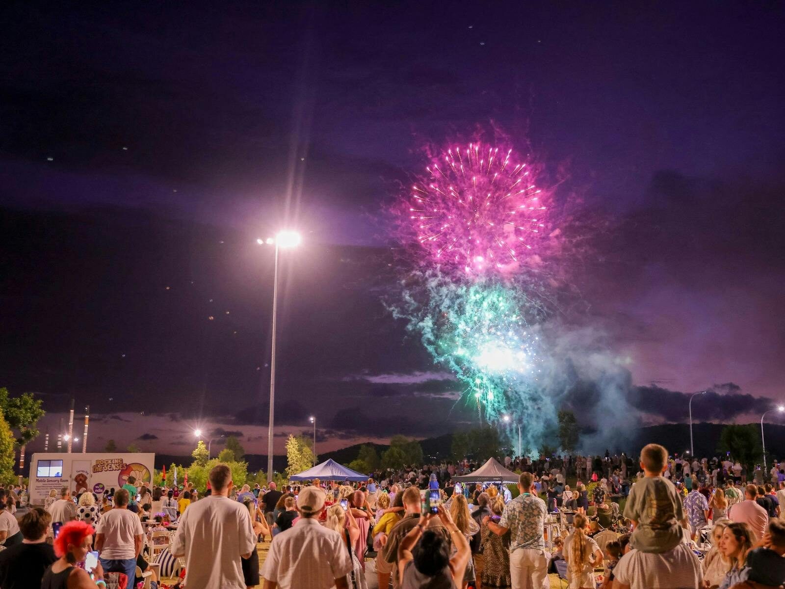 Fireworks bursting in the sky with a people watching them