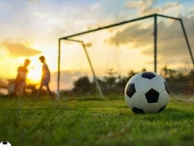 Sunset football goal with people playing