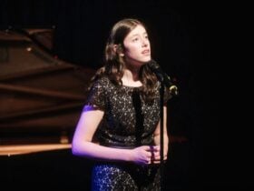 A young girl sings on stage