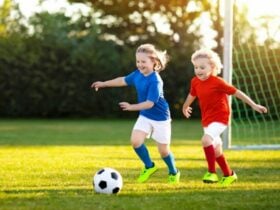 Two children playing soccer on a field