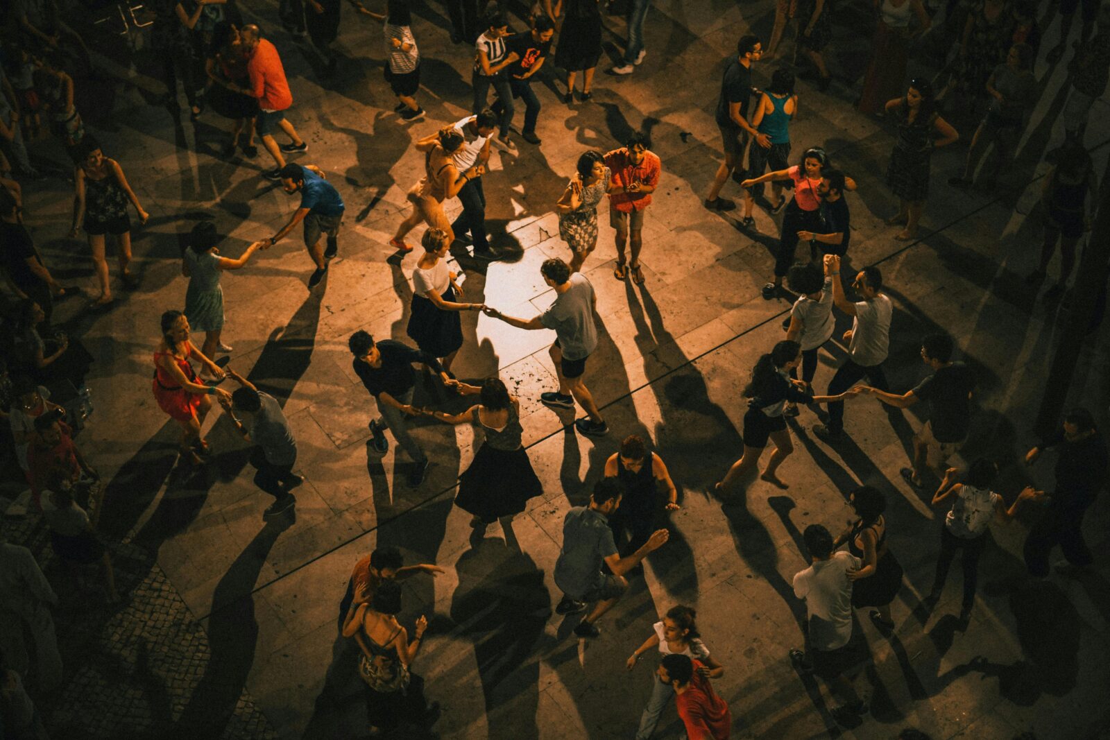 Birds eye view of people dancing on wooden floors, doing salsa and other latin dances.