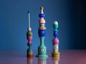 A photo of three colourful and sculptures made of objects piled on top of each other