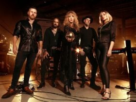 Band Starshine posing with crystal ball, stage lights, and instruments in the background.