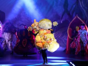 A yellow wearable art piece that encompasses the full body in spikey round forms.