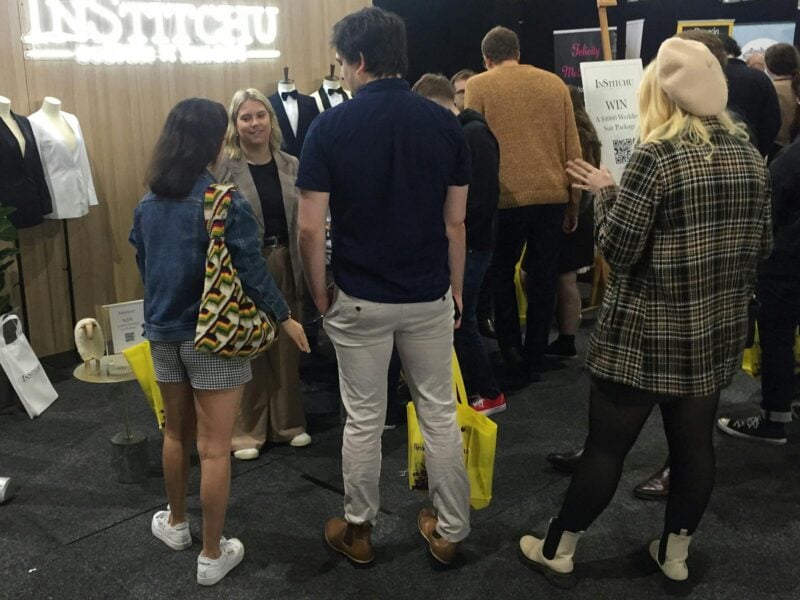 Attendees speaking with Institchu about suits at Your Local Wedding Guide Expo