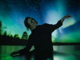 Woman dancing in front of Southern LIghts