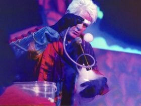 A man pouring chemicals into a flask causing a reaction of smoke