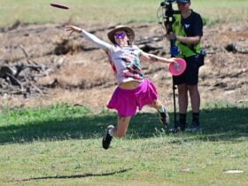 Girl throwing disc in pink skirt