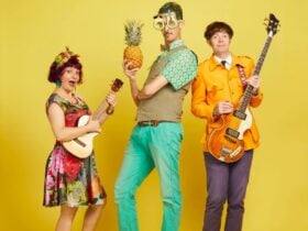 Promo photo of The Vegetable Plot wearing vibrant colours and holding instruments