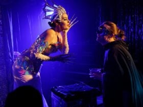 A performer holds something to her ear