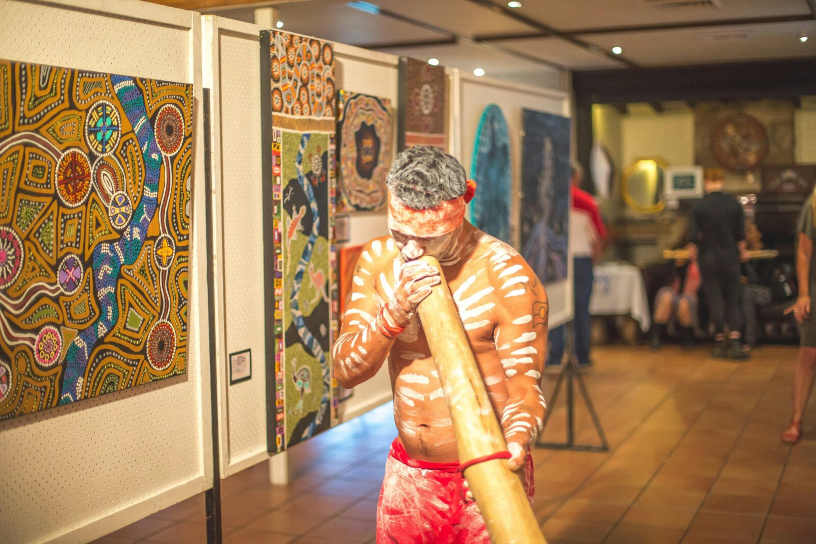 Performer plaing the yidaki as he leads guests throuhg the art display on wupa opening night.