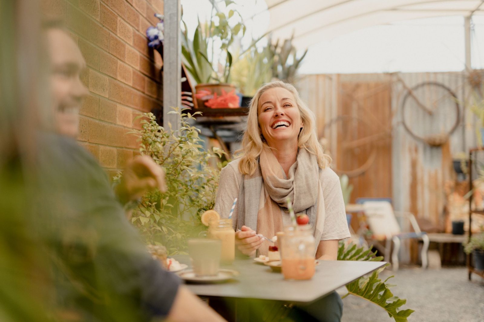 A man and woman sit enjoying food and drink outside Howlong