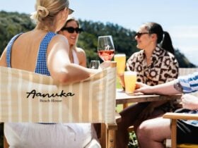 group of friends enjoying drinks outside on Aanuka Beach House branded deck chairs