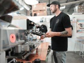 Specialty coffee barista steaming milk on a La Marzocco coffee machine.