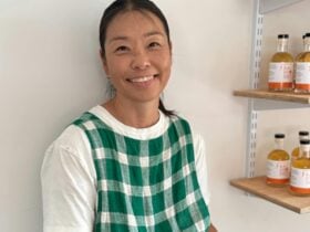 Julz is smiling near a shelf of vinegar