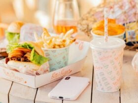 An image of a hamburger, fries and a drink on a tray