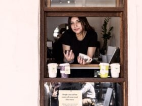 Female in window of cafe, order here sign above