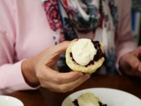 Holding a jammed scone. with cream.