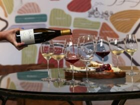 Wine being poured into glass with cheese board