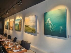 Image of tables set with ocean paintings on the walls.