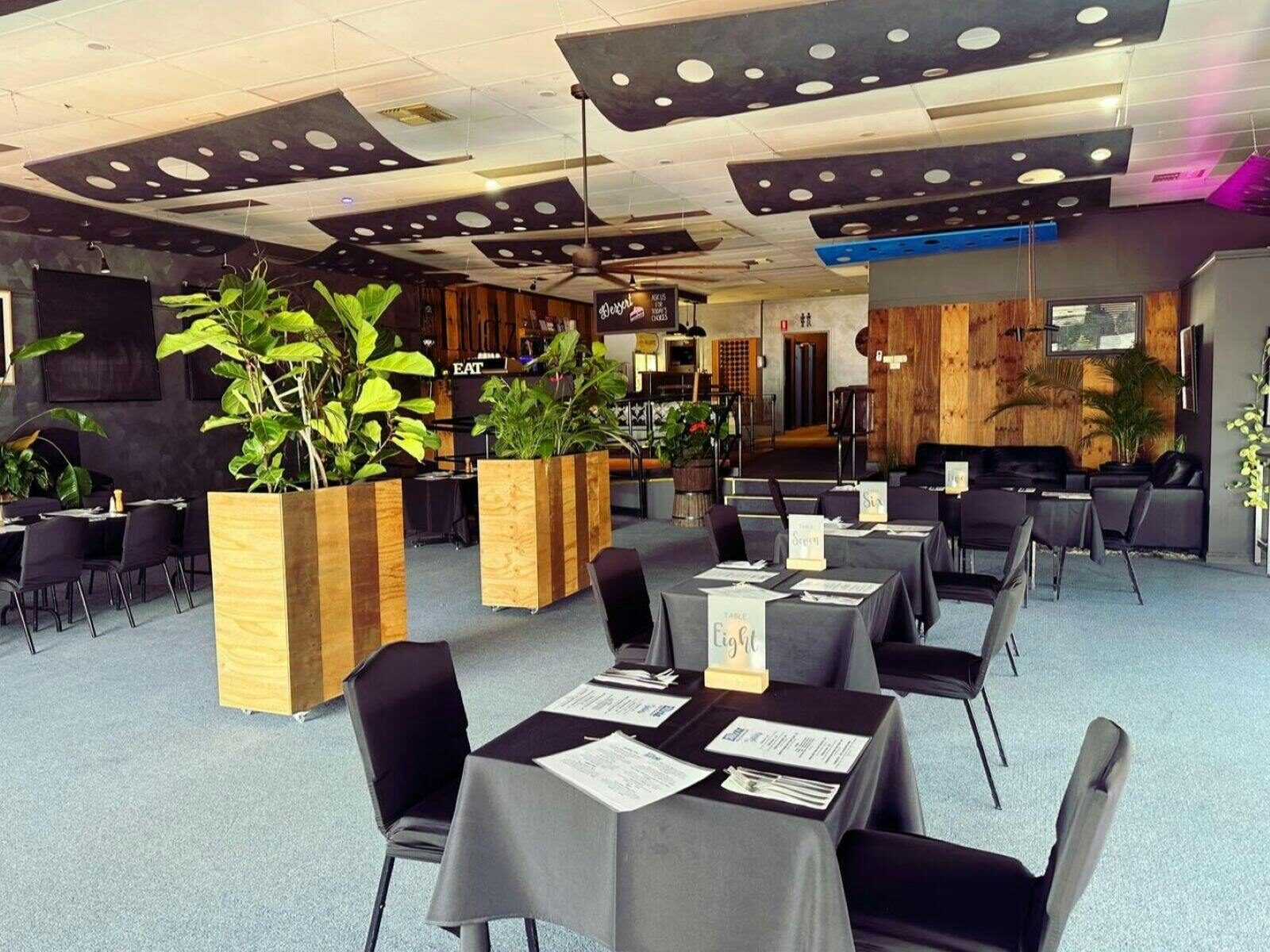 Dining area of Elliotz, dark and moody with lots of space between tables of twos and fours.