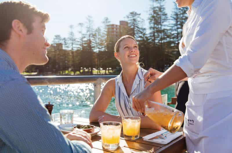 Couple enjoying food and drinks at Hugos Manly, at Manly Wharf