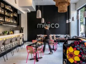 Table and chair set up, colorful skull candy host desk, tequila bar with high stools, mejico sign