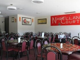 Seating in a restaurant with Red Narellan court sign