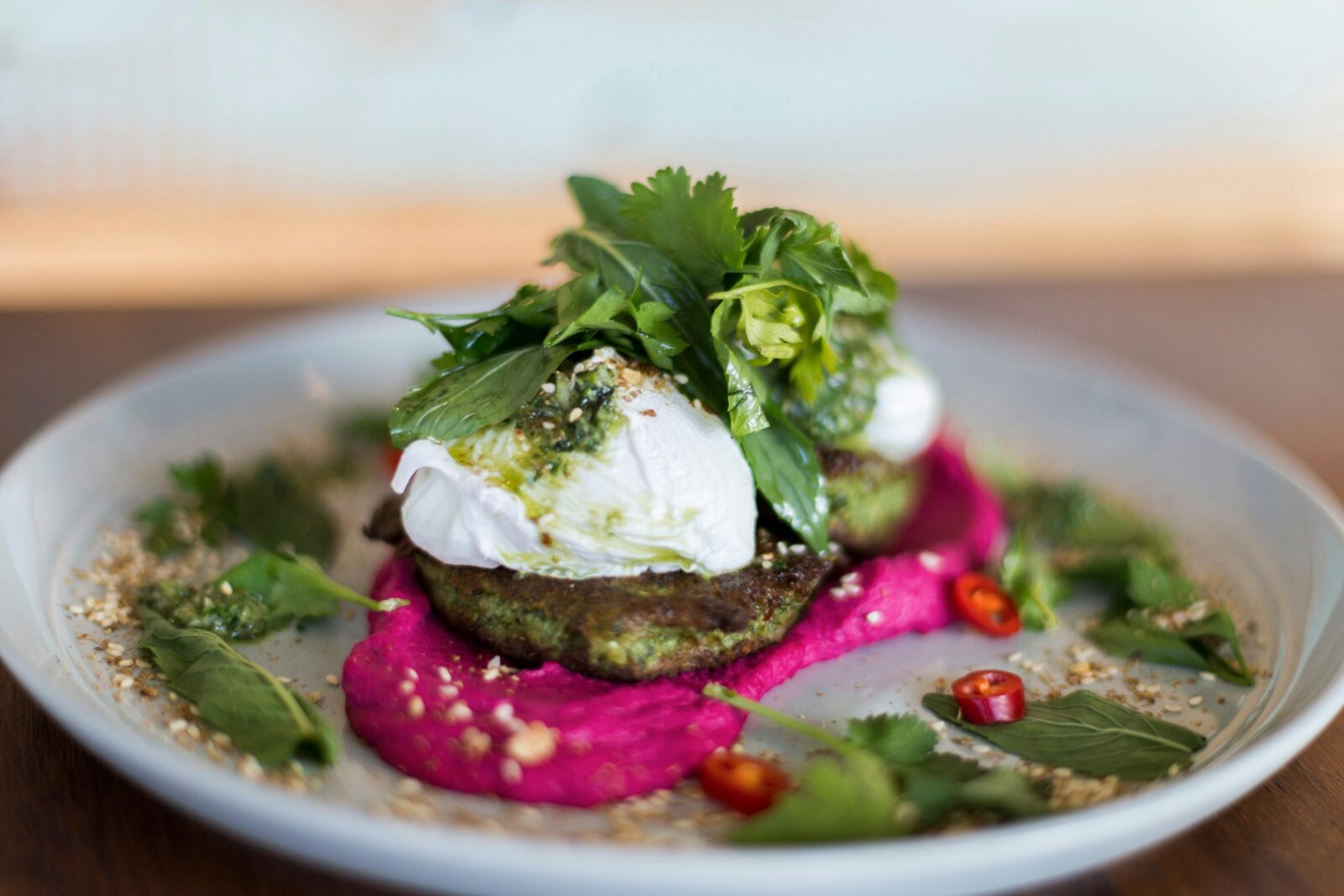Beetroot and quinoa fritters served with poached eggs and beetroot hommus