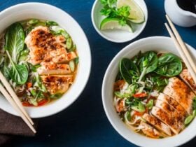 bowls of soup with a chicken breast, spinach and broth