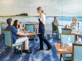 Waitress serving couple. Second couple enjoying food at another table. Wallpaper of Nobbys beach