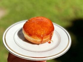 A doughnut covered in hard toffee is sitting on a plate