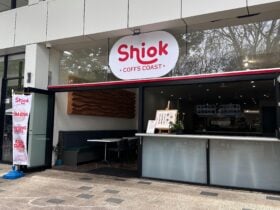 Exterior of Shiok Coffs Coast, an Asian fusion restaurant with red signage and open glass front.