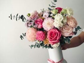 A seasonal colourful bunch of flowers arranged in a white vase.